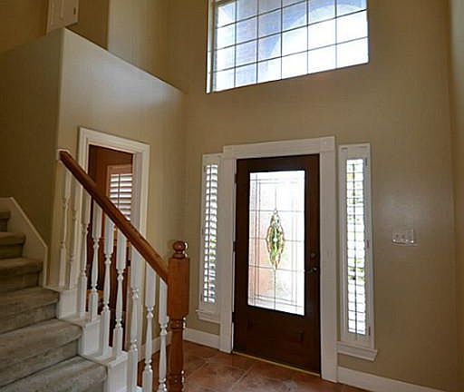 Elegant entry offering tile flooring, two story high ceilings, beveled glass front door and access to a half bath.