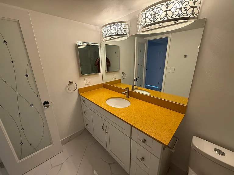 MASTER BATHROOM with limited-edition custom quartz countertop, large vanity mirror, dimmable designer lighting & step-in shower with spa massage jets