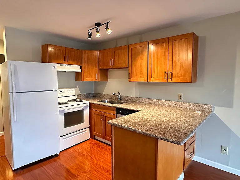 Kitchen with granite countertop, dishwasher, stove/range, refrigerator. Set up for 2 bar stools for breakfast counter in the kitchen.