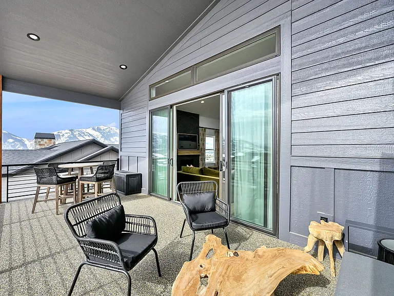 Front porch with sitting area and dining table.