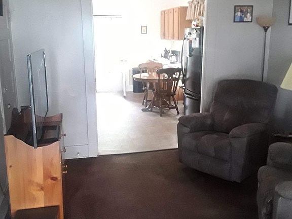 standing at front door looking at the living room and looking into the kitchen