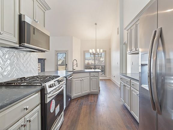 Kitchen and Eat-In Dining Area By Backyard. Subway Tile Backsplash in Herringbone Pattern.