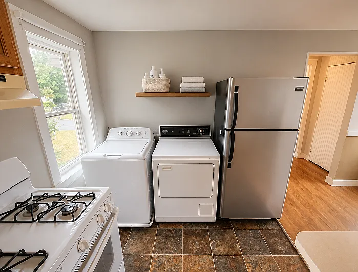 Stainless steel fridge, and laundry in the kitchen for convenience.