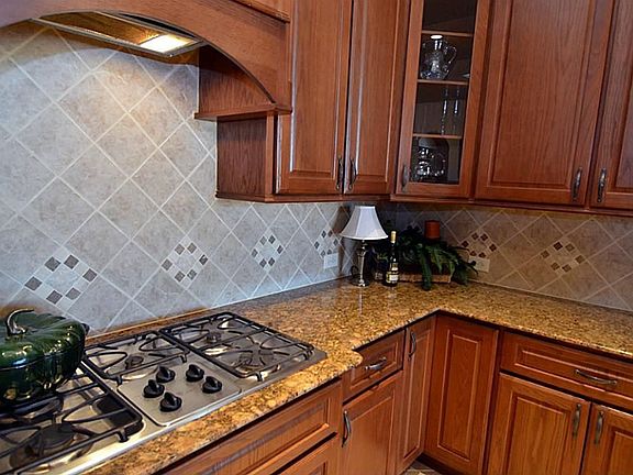 A view of the beautiful gas range and gorgeous countertops.