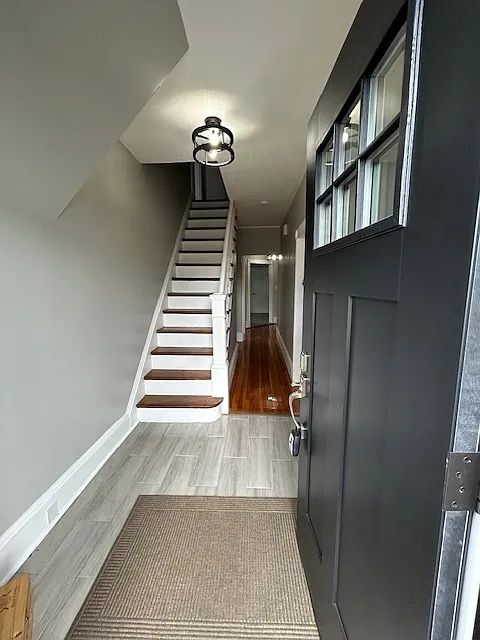 Main entrance showing stairs to the second level and hall way to the other living areas.