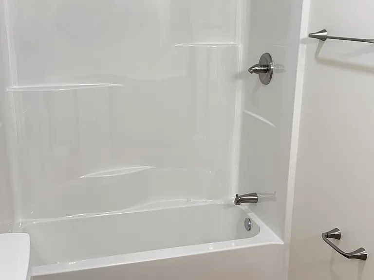 Modern bathroom vanity featuring a clean white cabinet with ample storage, bright countertop, contemporary round mirror, stylish three-light fixture, and coordinated finishes for a fresh, elegant look.