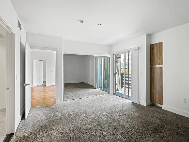 Bedroom with Closet, Cabinet Storage, and Balcony Access