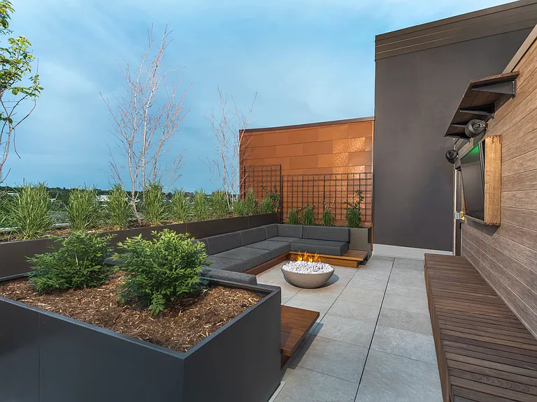 Rooftop deck with greenery, firepits, and lounge seating