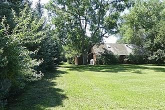 Side yard off patio area of cottage. Plenty of room for exercise, games or a picnic. Very private & lots of trees.
