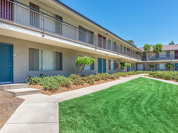 Exterior of apartment building. Walk paths leading to front doors.