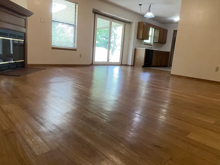 View from Hallway looking into LVRM, Kitchen, and Large Door that overlooks the Spacious Backyard.