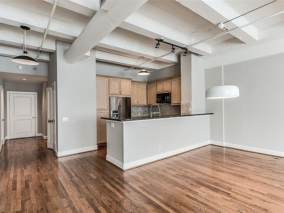 This loft has wonderful architectural elements including painted exposed cement ceilings, exposed ductwork, and wide crown molding and base boards throughout the home.