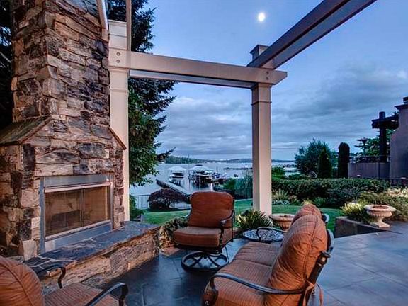Outdoor patio off living room with gas fireplace and arbor