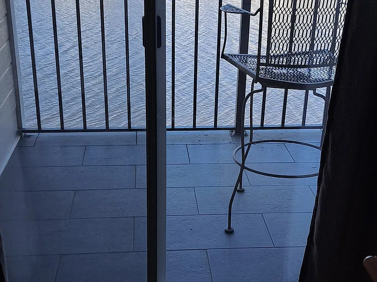 View from guest bedroom onto balcony with view of waterway