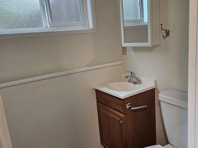 basement bathroom showing toilet and sink, looking NE