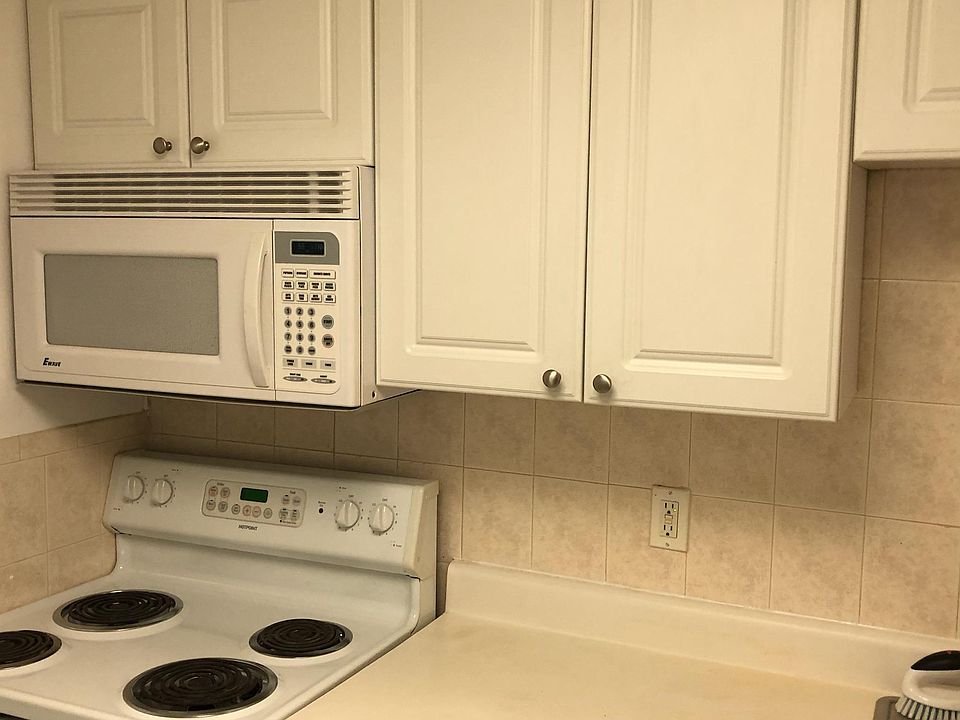 Kitchen, white cabinets, stove, microwave and fridge