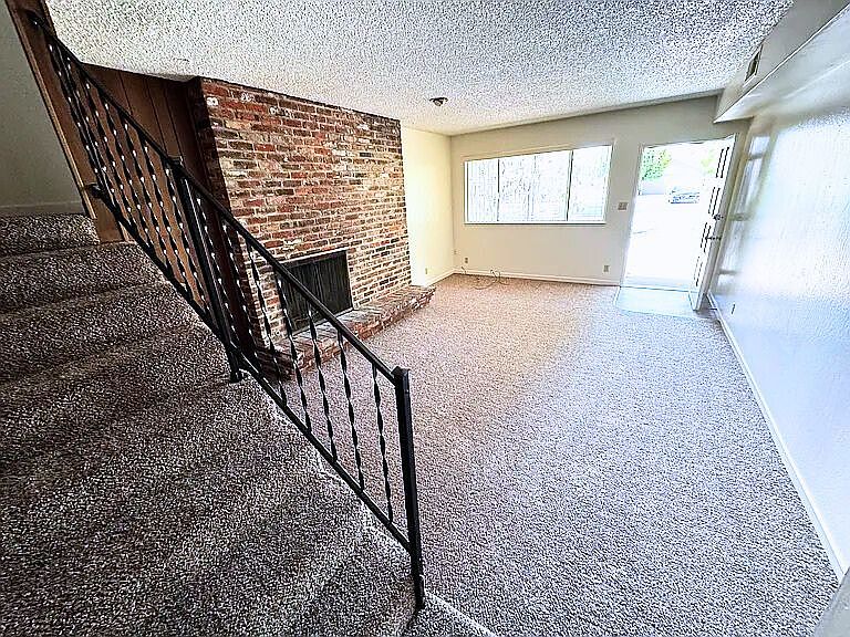 Living room with fireplace (view from kitchen)