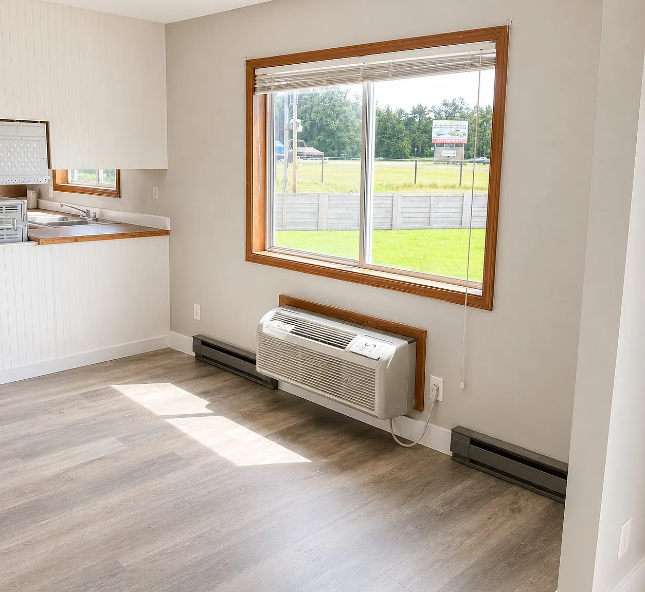 Bright open-concept living and kitchen area featuring abundant natural light, updated flooring, and a spacious layout perfect for everyday living