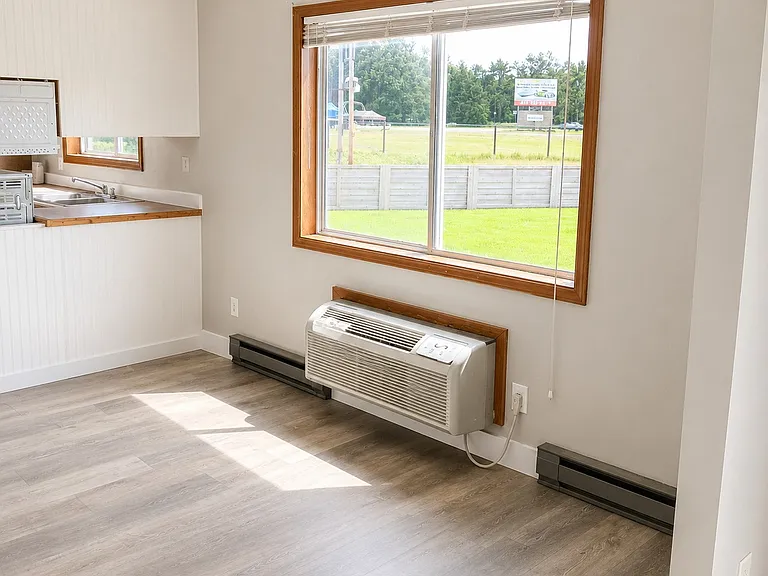 Bright open-concept living and kitchen area featuring abundant natural light, updated flooring, and a spacious layout perfect for everyday living