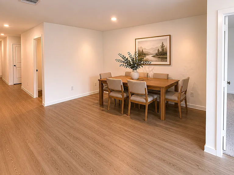 Modern dining room with natural light and seamless flow into the living and kitchen areas.