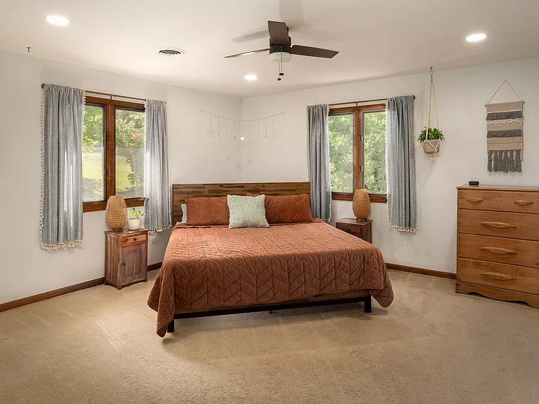 Spacious primary ensuite bedroom w/ king-sized bed, walk-in closet and 2 additional closets.
