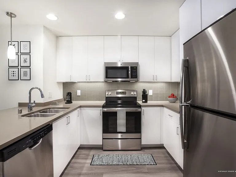 Modern Collection Kitchen with White Cabinetry Tile Backsplash Quartz Countertop Stainless Steel Appliances