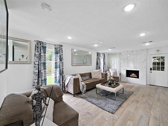 Spacious living room with fireplace. All the custom curtains will stay with the home