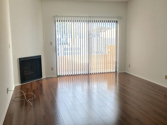 Large living room with fire place and sunny balcony