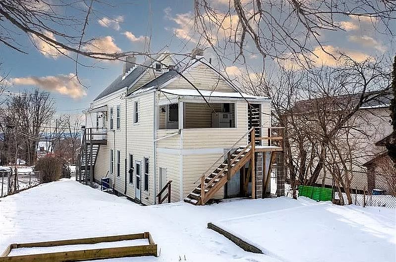 back of house with parking pad
