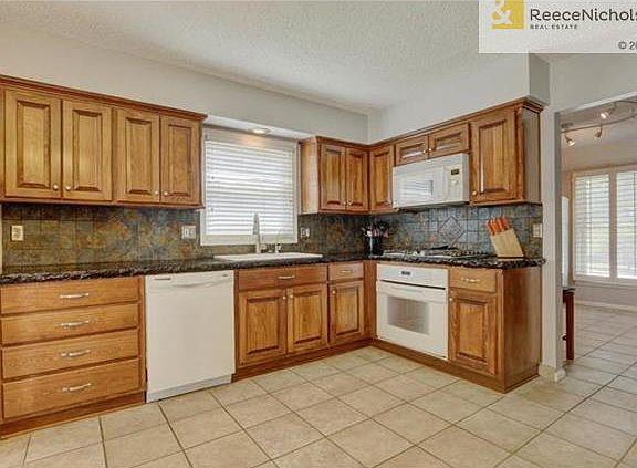 Gas cooktop and designer touches such as concrete counter tops & slate backsplash!