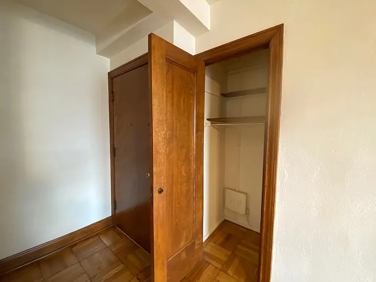 The coat closet, located directly next to the front entry door.