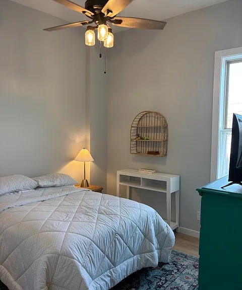Bedroom 2 with large East facing window and ceiling fan.