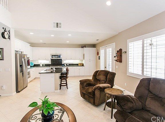 View from family room looking to kitchen. Tile flooring and plantation shutters.