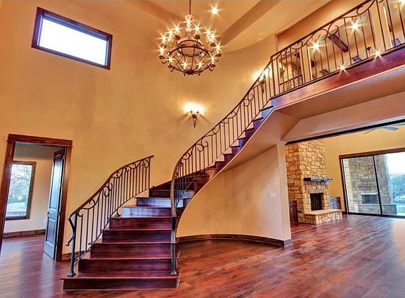 The stunning foyer includes the beautiful and dramatic curved staircase to the second floor, as well as a wide-open arch leading to the family room.