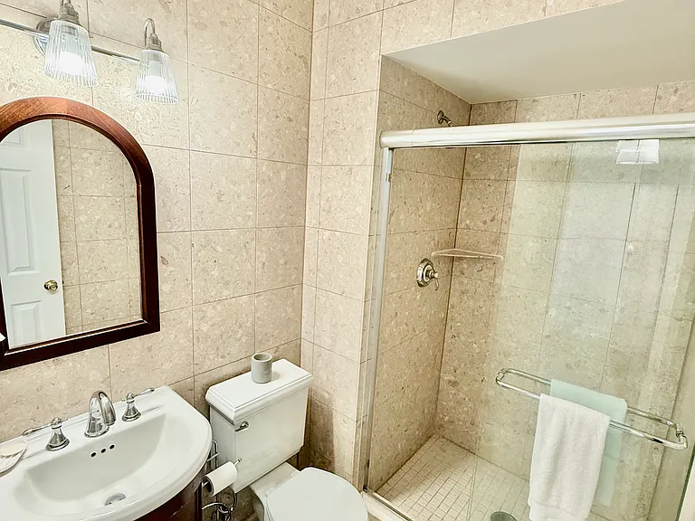 Bathroom with large shower, vanity cabinet and toilet.