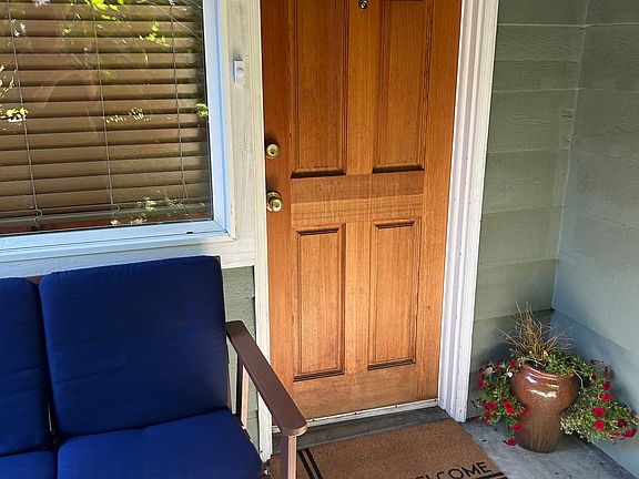 Private entrance with welcome mat and patio bench.