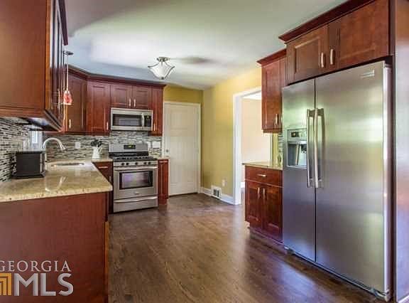 Gorgeous kitchen update with hardwoods, SS, granite. Wood cabinets w/ under lighting.  Glass-stone mosaic backsplash.