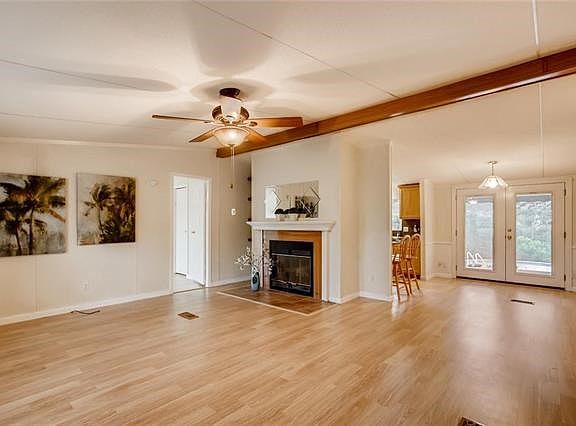 As you walk in, you're greeted by a welcoming fireplace, high ceilings, lovely flooring...and look at that view through the back door! The backyard won't disappoint!