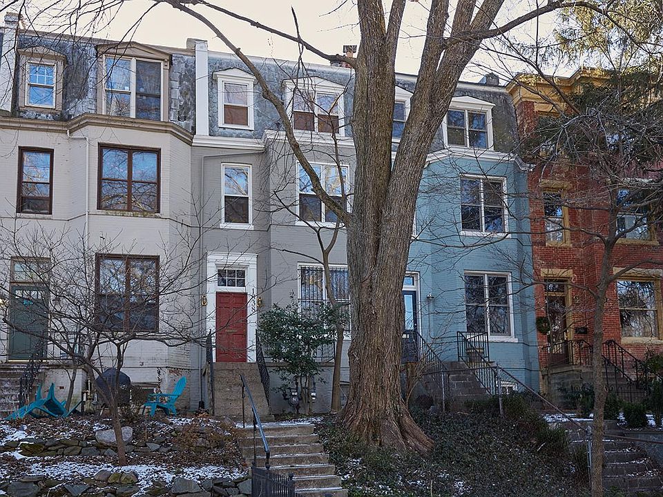 Victorian row house on tree-lined street.