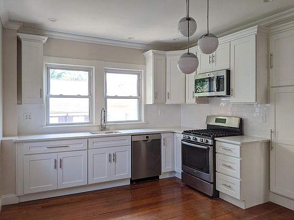 Kitchen with quartz counters, stainless steel appliances.