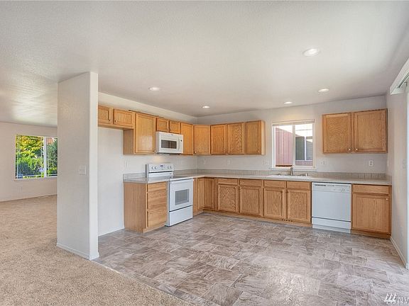 Light and bright kitchen sits nicely open to family room, allowing for one large space for gatherings and conversing.  Kitchens features new flooring, newer counters and Whirlpool appliances. 