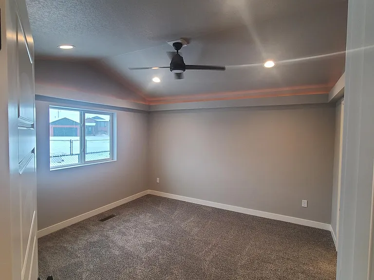 Master bedroom with vaulted ceiling and trayed lighting