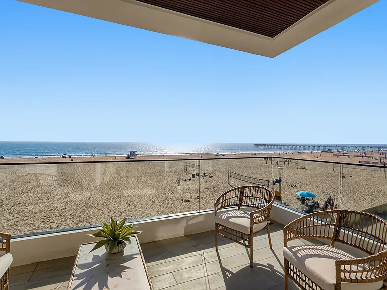 The main living room features breathtaking panoramic views from every corner, covered balcony, bar, and powder room.