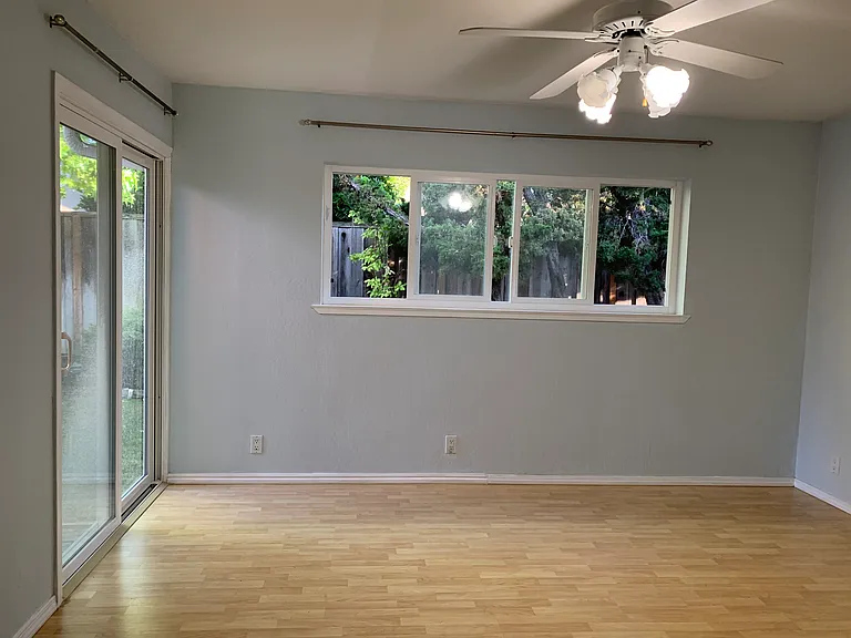Spacious primary suite with upgraded patio door and windows overlooking the private backyard