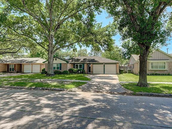 Nice mature trees shade the front yard, as well, as the driveway and garage area.