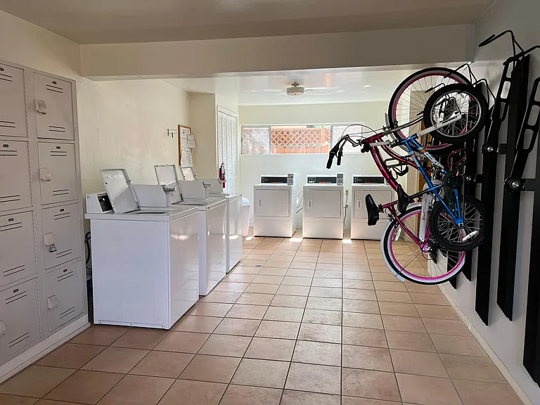 laundry room with lockers for laundry supplies and bicycle storage hooks