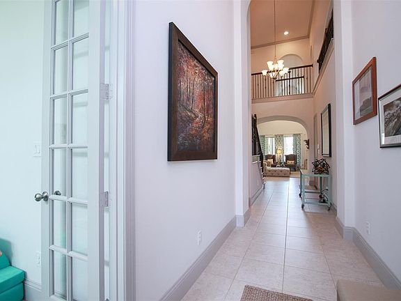 The entry foyer leads to the main living area of the home. Ahead is the catwalk on the 2nd floor and directly ahead is the den/family room. The study to the left is afforded privacy by French doors and it is located in the front of the home, separate