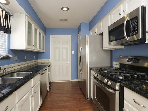 KITCHEN -From Dining area - Who wouldn't want to cook in this kitchen?Eye catching Stainless steel appliance's & wine fridge.MUST SEE tile backslash and cabinetry. Door leads to two car garage.Can lighting and beautiful granite counter tops!