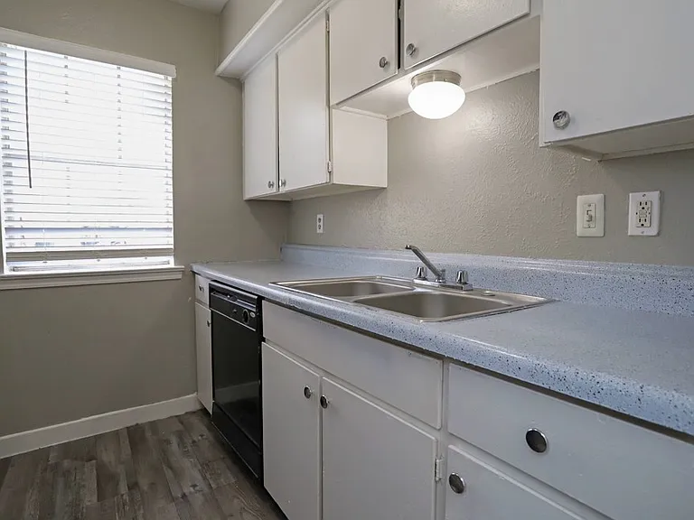 Bright kitchen with sleek countertops, white cabinetry, and updated fixtures.