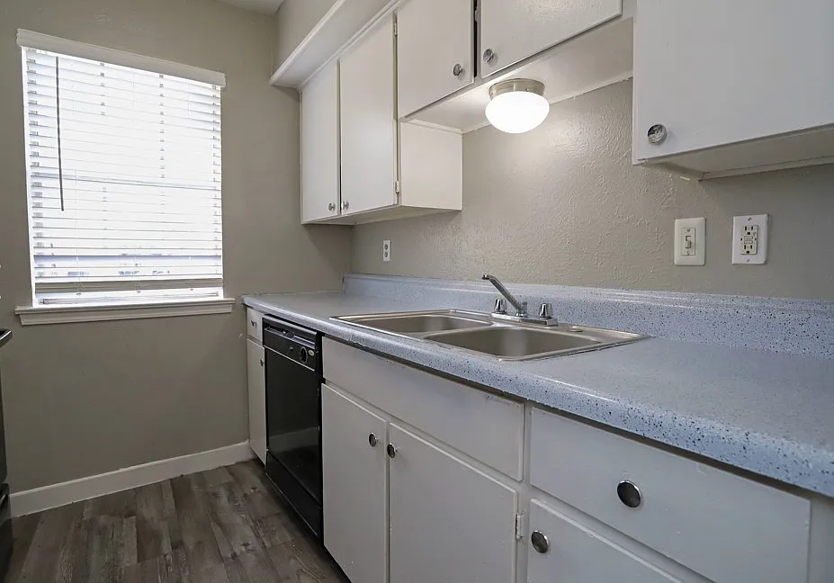 Bright kitchen with sleek countertops, white cabinetry, and updated fixtures.
